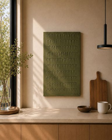 Tablero texturizado verde en una pared, con luz natural y decoraciones minimalistas.